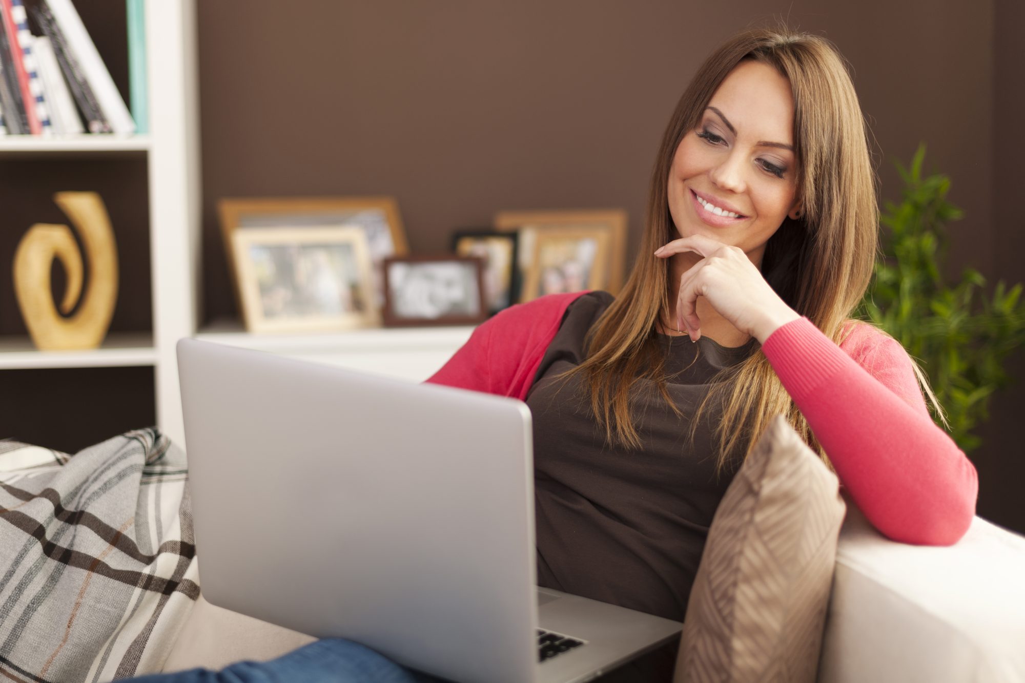 smiling woman using laptop home Eugenia Cervantes | Clínica Dental en Madrid